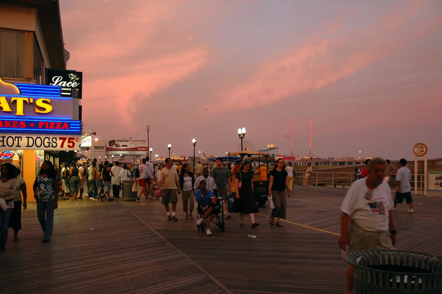 Crowds walking the Atlantic City Boardwalk at sunset